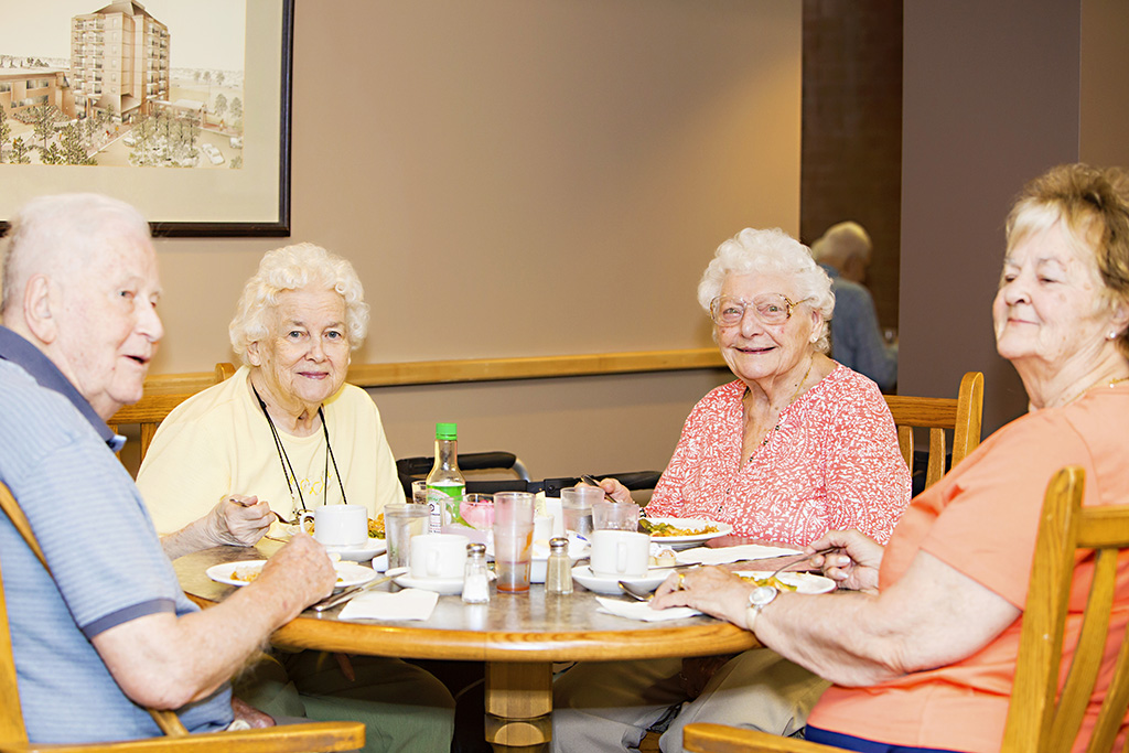 Group of residents enjoying a meal in the Woodland Towers Dining Room