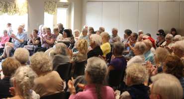 Happy Residents Clapping Hands in a Large Group
