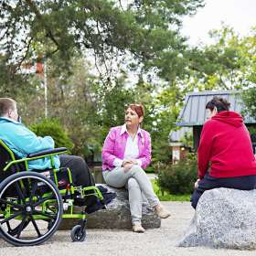 Two residents and Spiritual Care Coordinator enjoying conversation outdoors