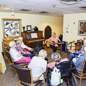 Group of residents enjoying musical therapy program in the chapel